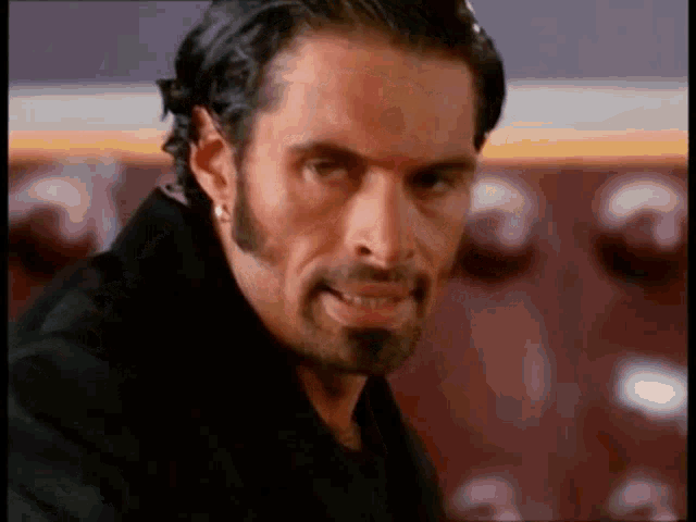a man with a beard and mustache is wearing a black coat