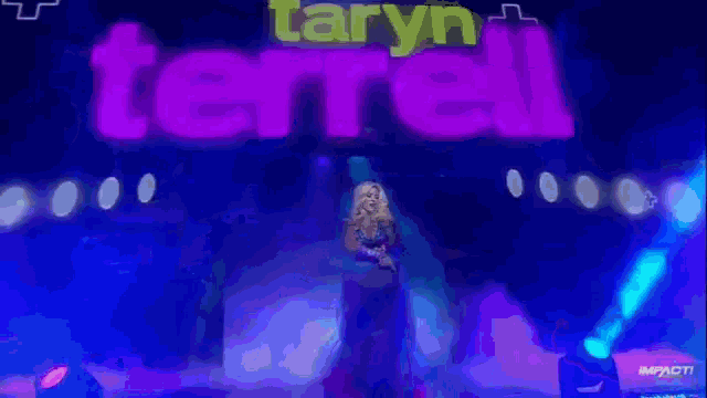 a woman stands on a stage in front of a sign that says terrell