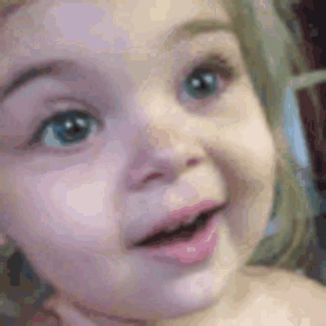 a close up of a baby 's face with a smile on her face .