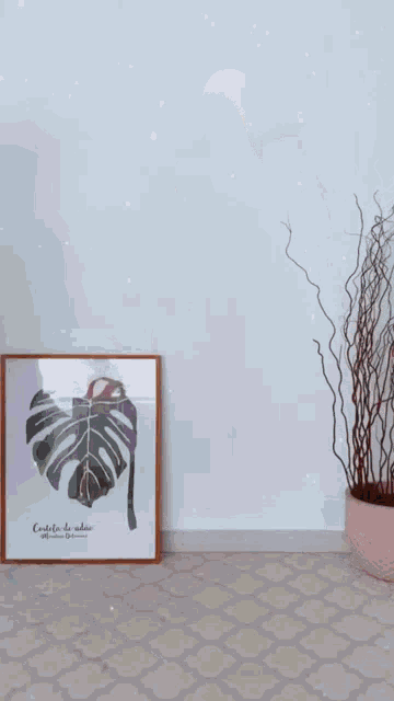 a woman in a purple dress holds a framed picture of a monstera plant