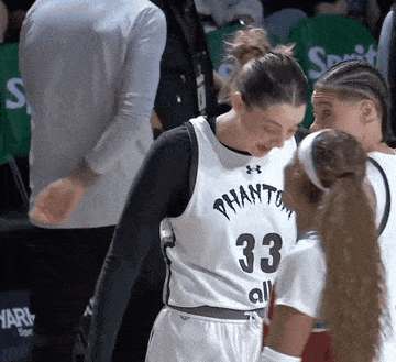 a female basketball player wearing number 33 talks to another player