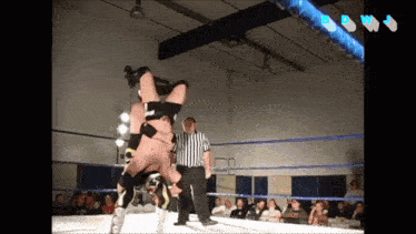 two wrestlers in a ring with a referee and the letters dwj on the bottom right