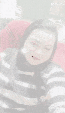 a woman in a black and white striped shirt is taking a selfie with her eyes closed .