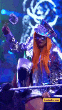 a woman with orange hair is holding a rose and wearing a hat that says ' wwe ' on it