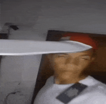 a man in a red hat is holding a knife over his head .