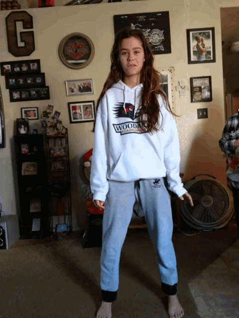 a girl is wearing a white hoodie that says woodward