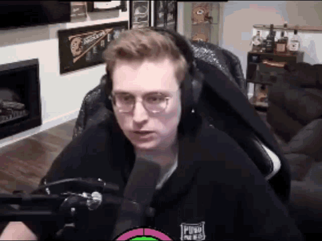 a man wearing headphones is sitting in front of a microphone in a living room
