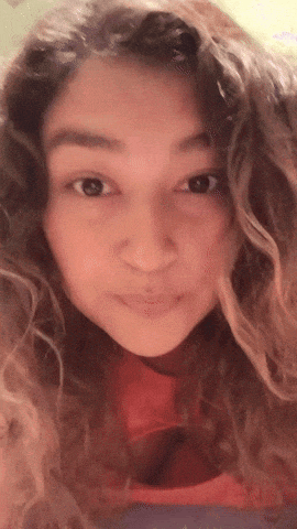 a close up of a woman with curly hair making a face
