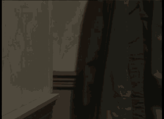 a stuffed animal with a big nose is peeking out from behind a wall