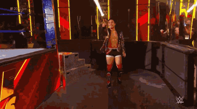 a man in a gold robe is walking on a stage in front of a sign that says ' igglive ' on it