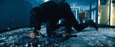 a person is crawling on the floor with a knife