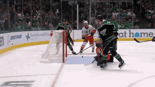 a hockey game is being played in front of an ad for boeing health