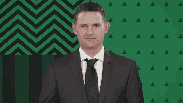 a man in a suit and tie with a green background