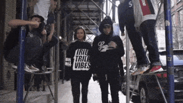 a group of people are posing for a photo and one of them is wearing a shirt that says " true tril vibes "