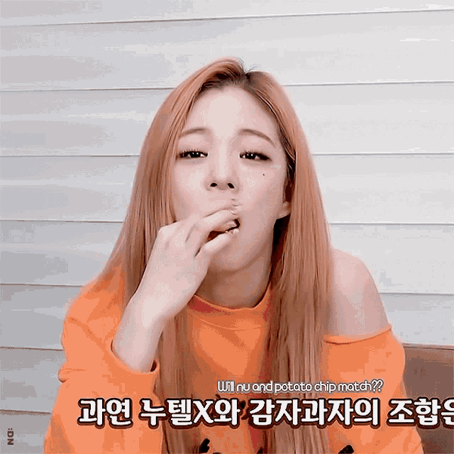 a girl in an orange sweater is eating a potato chip and the caption says will nu and potato chip match