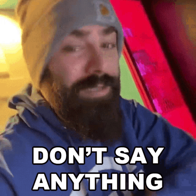 a man with a beard wearing a beanie and a blue hoodie says do n't say anything