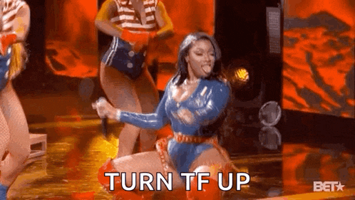 a woman is kneeling down on a stage with a microphone in her hand and the words `` turn tf up '' .