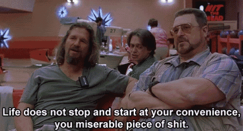 two men sitting in a bowling alley with a sign that says hit the head