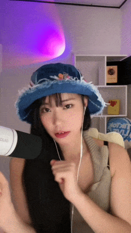 a woman wearing a blue hat and ear buds stands in front of a microphone that says duo on it