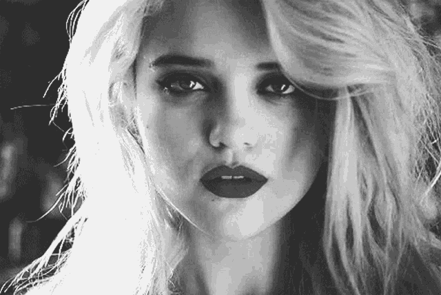 a black and white photo of a woman with red lipstick .