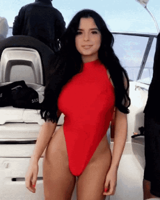 a woman in a red swimsuit is on a boat