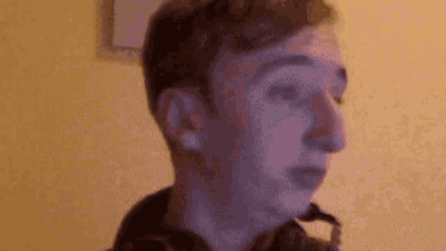 a close up of a man 's face with a purple background .