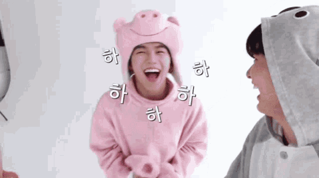 a man in a pig hat is laughing next to another man in a shark hat .