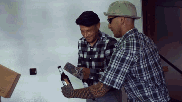 two men in plaid shirts are looking at a bottle