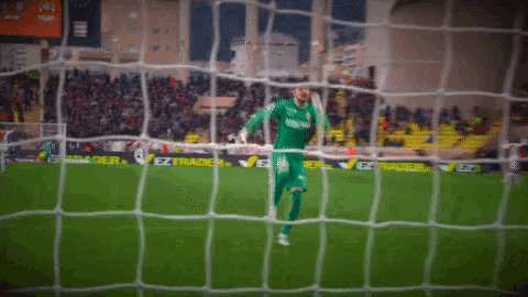 a soccer player wearing a jersey that says ' bwin ' on it is jumping in the air