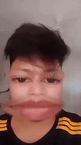 a young man is making a funny face with his mouth open and his eyes closed .