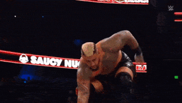 a wrestler is jumping over another wrestler in a ring