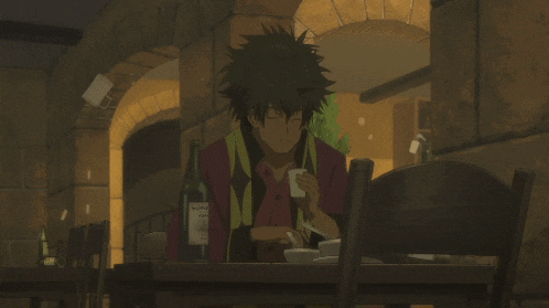 a man sits at a table with a bottle of wine in front of him that says ' nirvana ' on the label
