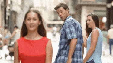 a man and a woman are walking down a street .