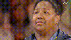 a woman is wearing a medal around her neck with the olympics logo on it