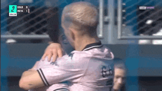 two soccer players hugging each other in a locker room .