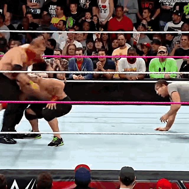 a wrestling match is being shown on a screen with the hashtag #thenextthing