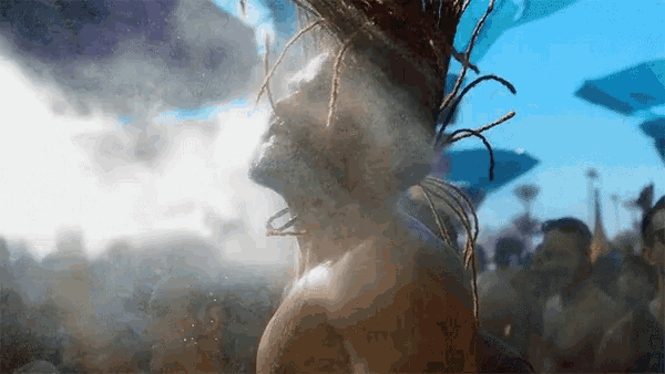 a man with dreadlocks is standing in a crowd