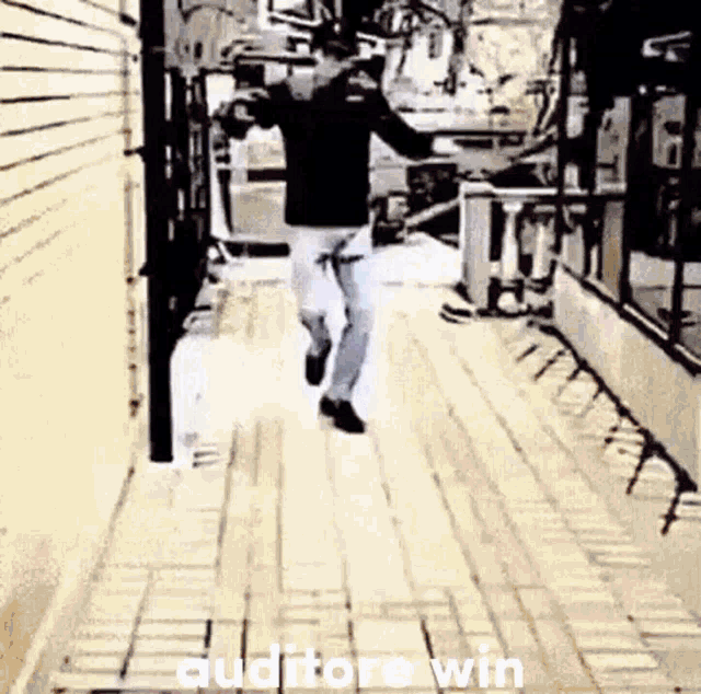 a man is running down a sidewalk with the words `` auditore win '' written on the ground .