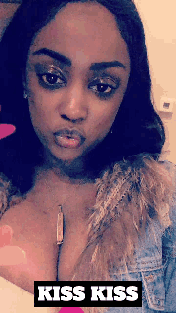 a woman taking a selfie with a kiss kiss sticker on it