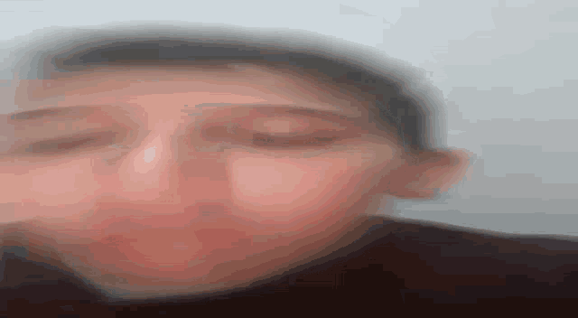 a close up of a person 's face with a blurred background