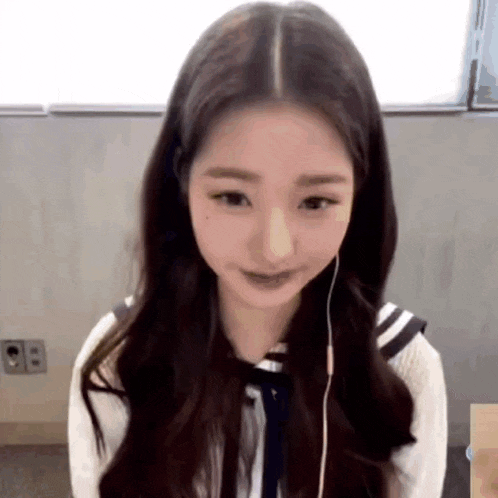 a close up of a girl wearing headphones and a sailor uniform .