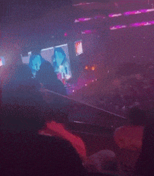 a crowd of people watching a concert with a sign that says exit on it
