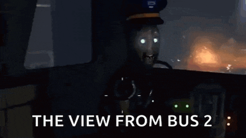 a man is sitting in the driver 's seat of a bus looking out the window .