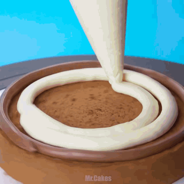 a chocolate cake is being frosted with white frosting and the word mr.cakes is on the bottom