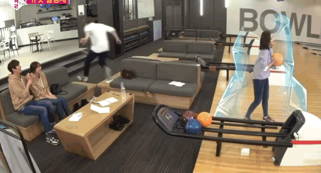 a group of people are playing bowling in a bowling alley
