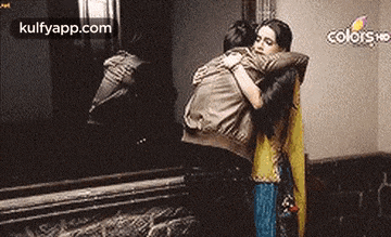a man and woman are hugging each other in a room .