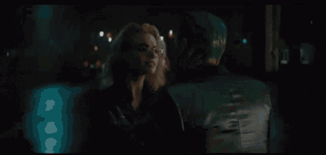 two women are standing next to each other in a dark room