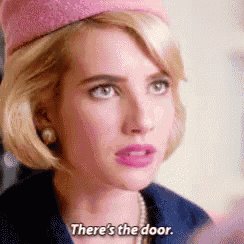 a woman wearing a pink hat and a blue jacket is saying `` there 's the door '' .