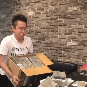 a man in a white shirt with the word world on it is smoking a cigarette while holding a box of money