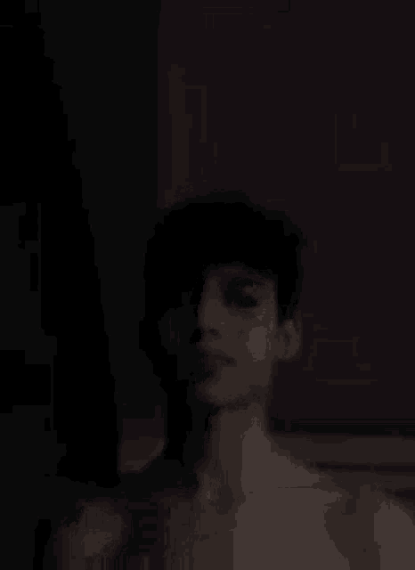 a shirtless man is taking a selfie in the dark .